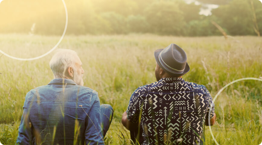 two men sitting in field talking